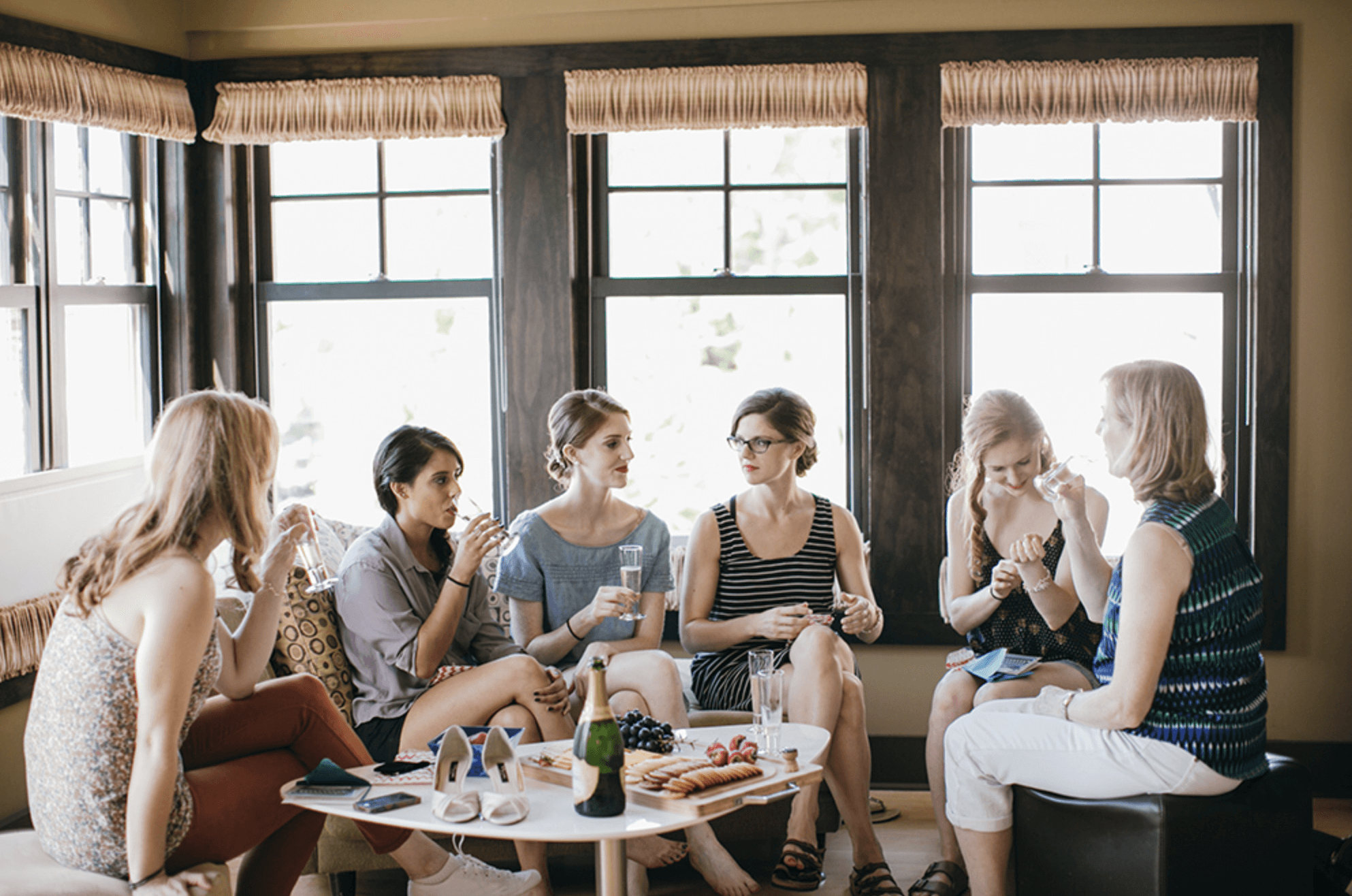 A group of women sitting around a table drinking wine at the lake house inn.